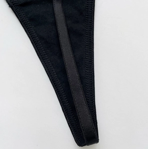 Detailed close-up of high-quality black velvet flower mesh thong with fine stitching