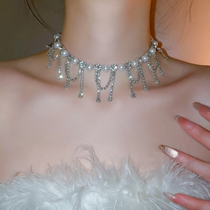 Detail view of pearl necklace with rhinestone flower and long hanging tassels on neck