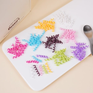 Colorful spiral telephone wire hair ties displayed on a white tray for hair styling