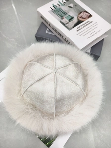Detail of cream plush earflap hat featuring faux fur trim and leather crackle texture
