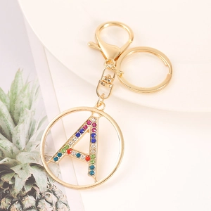 Golden letter A keychain with colorful rhinestones on a white plate, stylish metal pendant