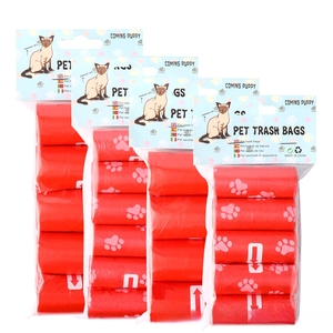 Detail of red biodegradable dog poop bags with white paw prints and retail packaging