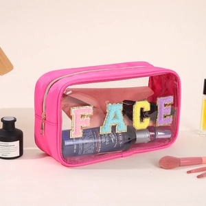 Macro shot of pink nylon and clear PVC makeup bag with FACE chenille embroidery and gold zipper