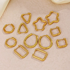 Set of 12 gold geometric earrings in various shapes like star and hexagon on beige silk
