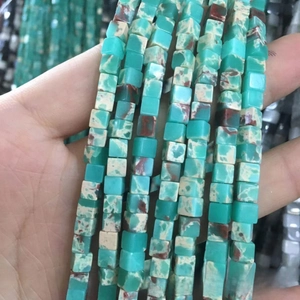 Gros plan de perles carrées en turquoise naturelle avec texture minérale pour bijoux DIY