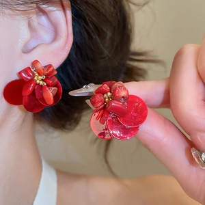 Close-up of red floral cluster earrings with golden beads and shell-like petals