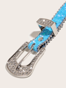 Close-up of a blue sequin belt with silver rhinestone buckle and metal rivet studs