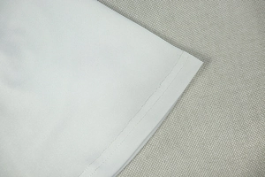 Detail of double-needle hem stitching on light gray solid color A-line dress fabric