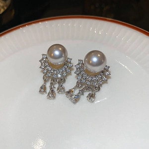 Detailed close-up of pearl earrings with cascading drop-shaped zircon crystals