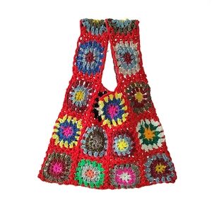 Close-up of vibrant crochet granny square stitching and colorful yarn textures on the bag
