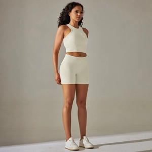 Side view of cream seamless knitted yoga set with racerback top and high waist shorts