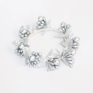 Macro detail of silver Christmas napkin ring with textured berry and leaf elements