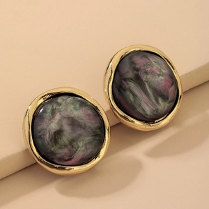 Detail of round vintage resin earrings with gold trim and marble texture inlay