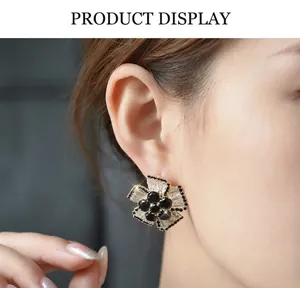 Detailed macro shot of a crystal flower earring worn on ear featuring black and white zircon