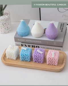 Detailed view of geometric scented candles in cone and cube shapes for home decor