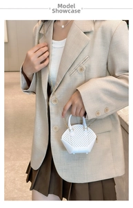 Mini white pearl shell bag with chain strap shown on model in a stylish indoor setting