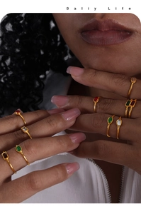 Macro shot of minimalist gold titanium rings featuring various colorful zirconia stones