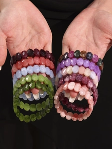 Détail de bracelets de perles en pierre naturelle facettées sur les mains