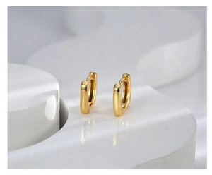 Macro shot of polished gold geometric square hoop earrings with minimalist metal clasp details