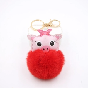 Cute pink pig plush keychain with a large red faux fur pompom and gold metal ring