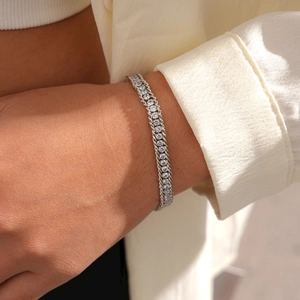 Close-up of a silver intertwined chain bracelet with sparkling zircon stones on a wrist