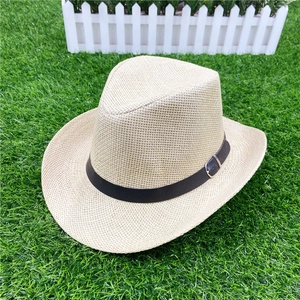 Detail of straw fedora hat featuring a brown faux leather band with metal buckle
