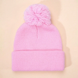 Pink knitted winter hat for kids featuring a large fluffy pom-pom and ribbed cuff