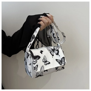 Detail of trendy white square handbag with black butterfly print and matching shoulder strap