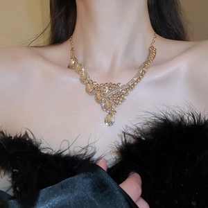 Close-up of luxury gold teardrop pendant necklace with champagne crystals and diamonds