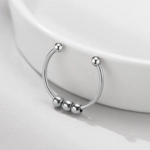 Detail of adjustable silver steel ring with three sliding beads on ceramic edge