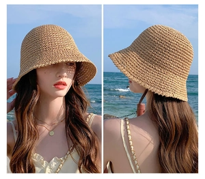 Detail of straw sun hat with breathable weave and wavy brim on a summer beach background