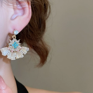Macro shot of fan-shaped earring with blue flower crystal and sparkling rhinestones
