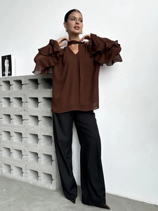Detail of layered ruffle bell sleeves on a dark brown chiffon blouse with elegant V-neckline