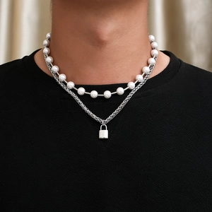 Close-up of double-layer necklace with white pearls and silver lock pendant on model