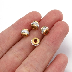18k gold plated stainless steel spacer beads with rhinestones shown on fingertips for scale