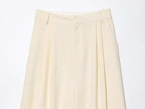 Gros plan d'un pantalon taille haute crème avec doubles plis et tissu texturé
