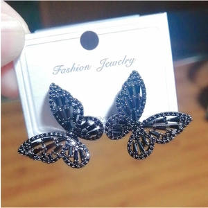 Elegant black hollow butterfly earrings with sparkling cubic zirconia on a jewelry card