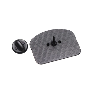Black plated metal badge back showing honeycomb texture and rubber clutch attachment