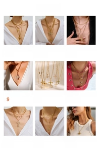 Close-up of assorted stainless steel cross pendants and layered necklaces with zircons
