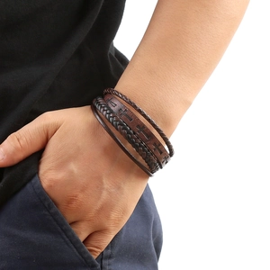 Macro shot of dark brown multi-layer braided leather bracelet with cross embossing