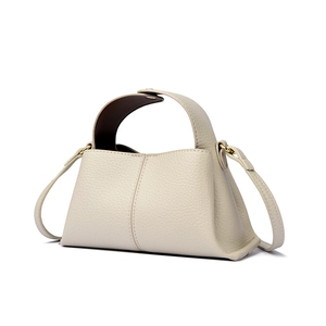 Close-up of off-white leather handbag showing high-quality grain texture and straps