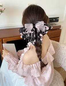 Rear view of a floral chiffon bow hair clip styled in a romantic braided hairstyle