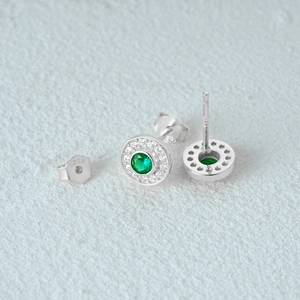 Macro shot of S925 silver stud earrings with green center stone and white accents