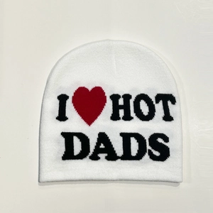Detail of white knit beanie featuring I Love Hot Dads jacquard letters and red heart