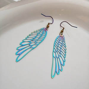 Macro shot of iridescent hollow feather earrings with colorful metallic finish and hooks