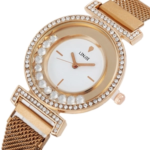 Gros plan sur le cadran montre or rose avec cristaux mobiles et bracelet maille milanaise