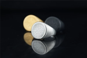Macro detail of octagonal star compass rings in silver, gold, and black brushed steel