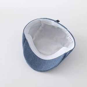 Detail of baby denim beret featuring 100% cotton material and size 48 labels