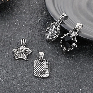 Detail of vintage silver titanium steel pendants including star and saint relief motifs