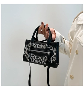 Bolso con estampado de leopardo, ribete de cuero negro y detalle de cremallera con borla
